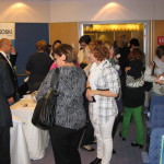 Osallistujia näyttelleasettajien tuotteiden parissa